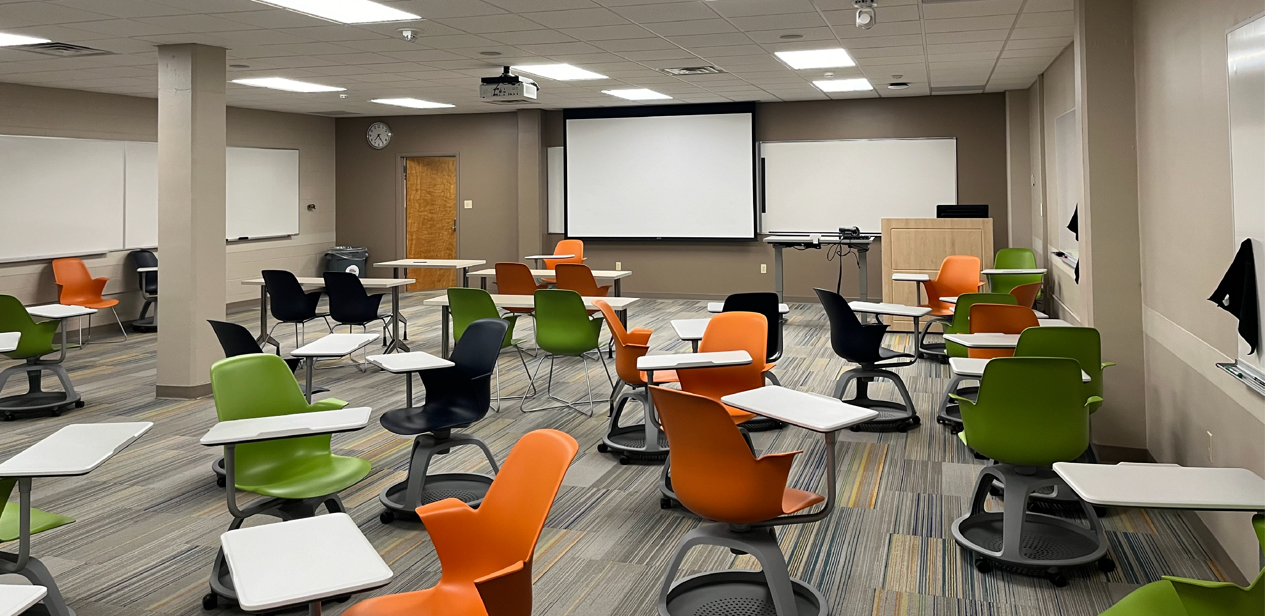 Health, Physical, Education, and Recreation 31A. Room includes individual desks and chairs that can be moved into different configurations. Instructor podium includes the control panel, instructor screen, and a spot for laptop. Next to the podium is a table that includes the document camera. The document camera table can be raised and lowered by pressing a button on the front of the table.