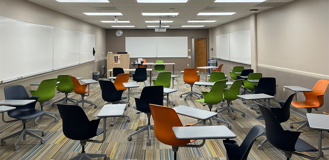 Health, Physical, Education, and Recreation 31B. Room includes node chairs that can be moved into different configurations. Instructor podium includes the control panel, instructor screen, and a spot for laptop. Next to the podium is a table that includes the document camera. The document camera table can be raised and lowered by pressing a button on the front of the table.