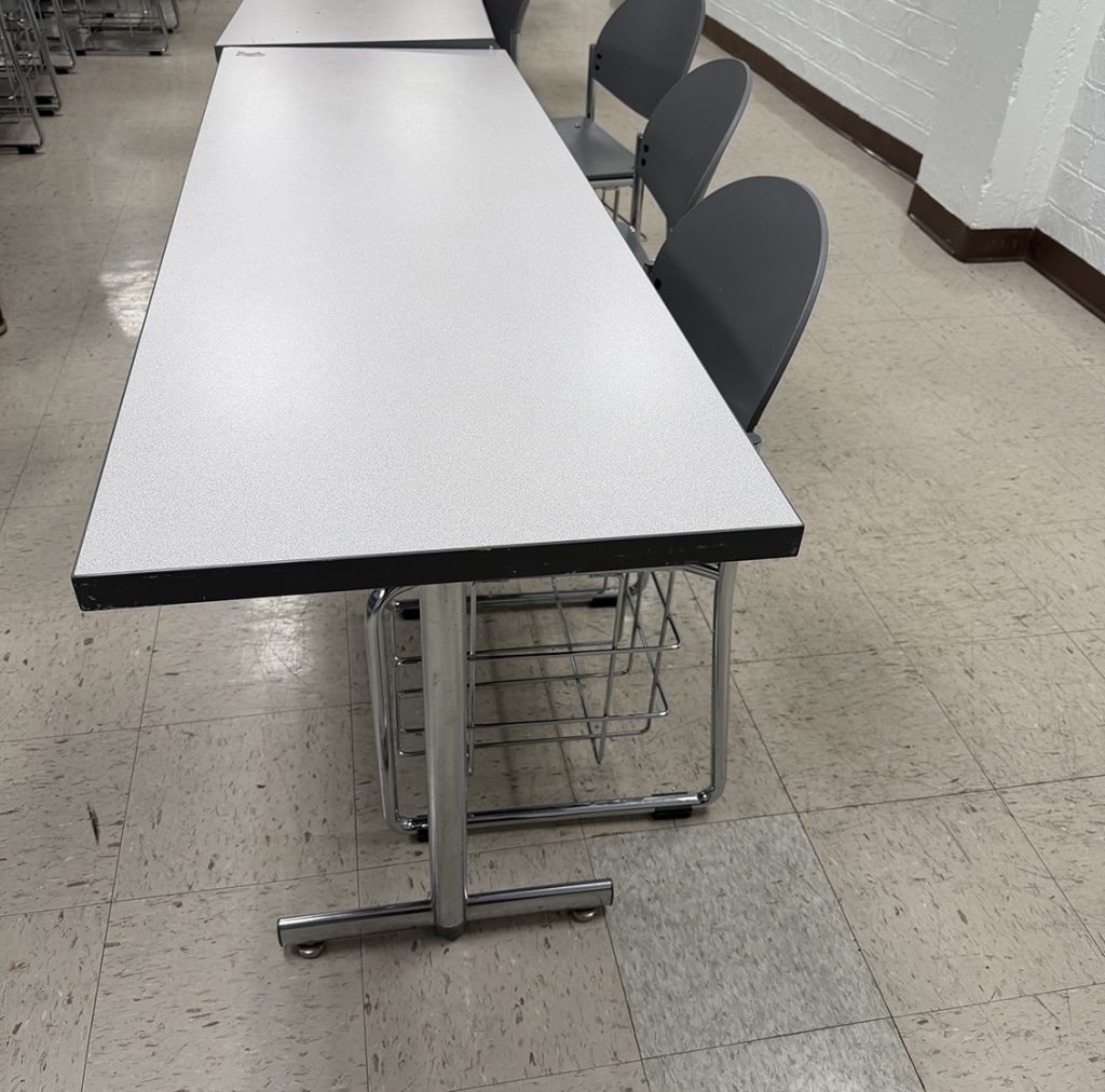 shows a long table with two chairs pushed in, with a similar table in a row cut off in the picture next to it.