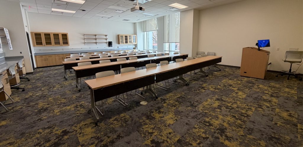 tables for students in rows facing podium for instructor