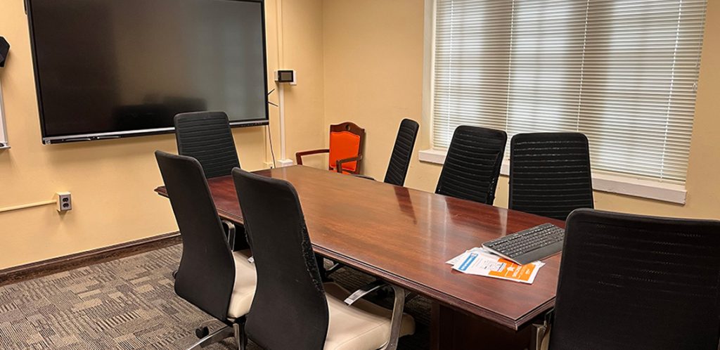 Austin Peay building room 308. Conference table in the middle of the room with chairs surrounding and tv visible.