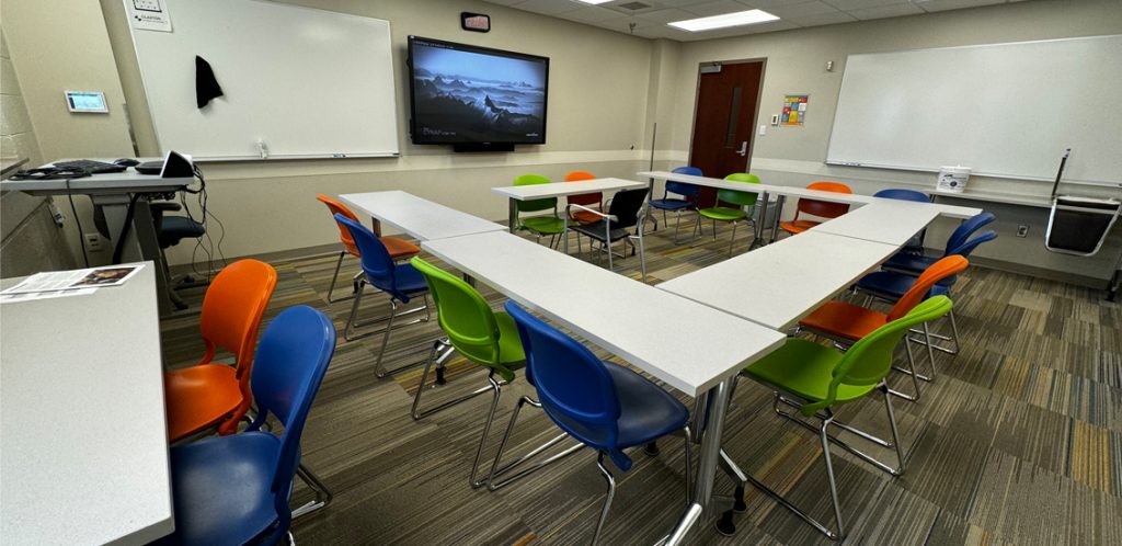 Claxton room 211 with tables in U formation and chairs surrounding.