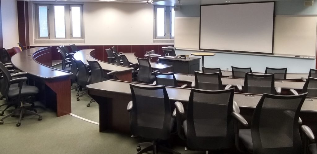 Claxton room 206 showing tables with chairs in lecture hall. Steps lead down to instructor podium