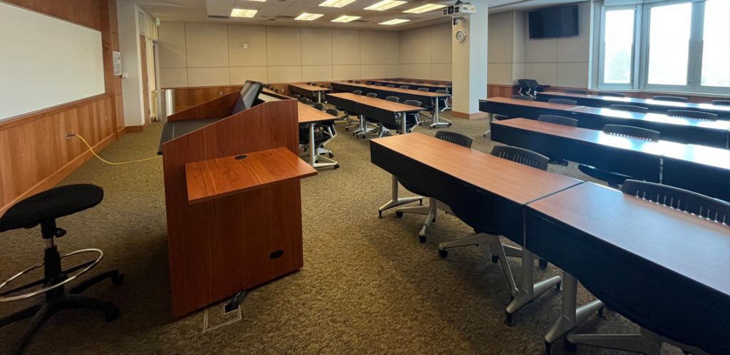 Haslam Business Building 423. Room includes tables and chairs. Instructor podium includes the control panel, instructor screen, and a spot for laptop.