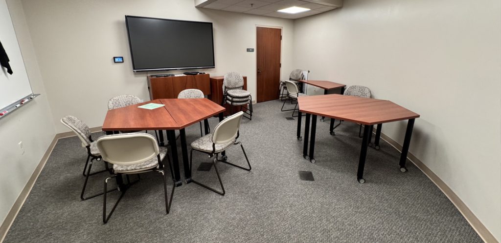 tables and chairs facing wall monitor