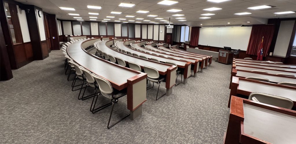 tiered seating classroom facing projector screen at bottom