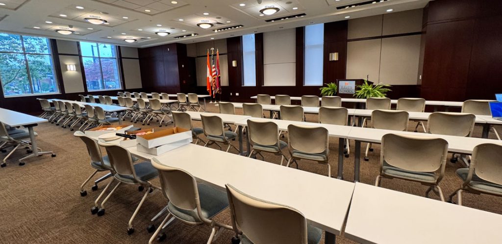 Toyota Auditorium in the Howard Baker School. tables and chairs aligned in rows facing projector screen